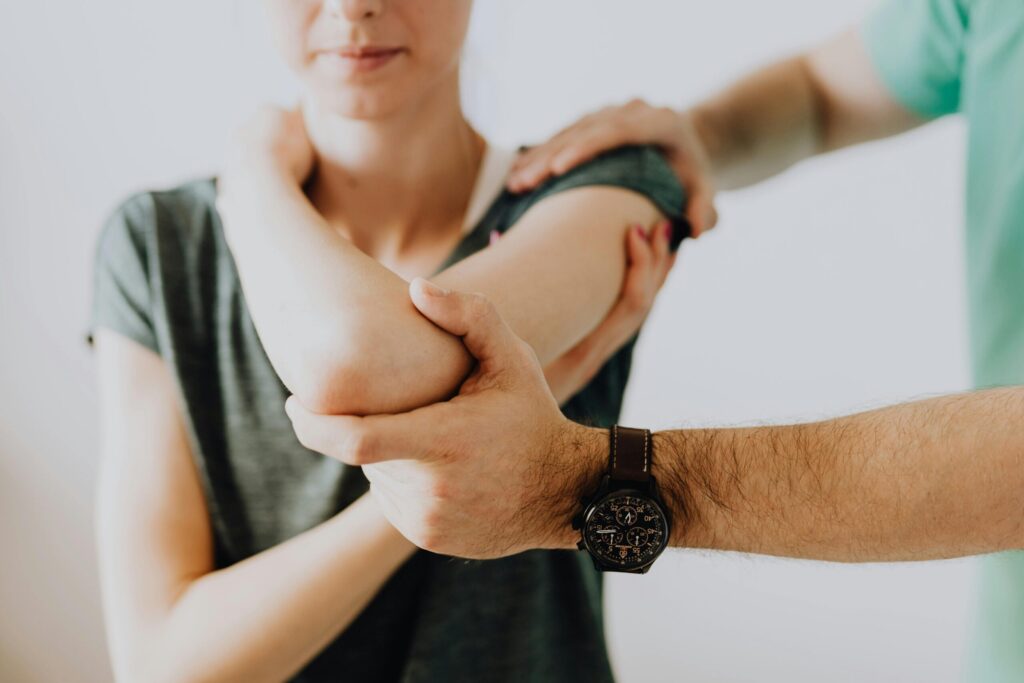 chiropractor examining arm joint of a female patient