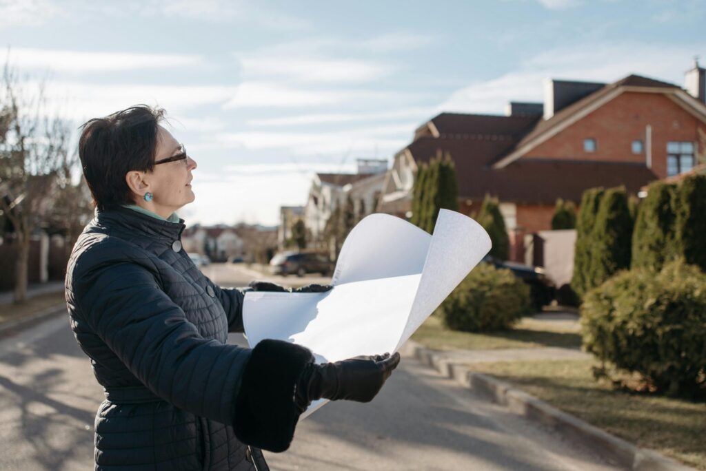 woman in blue jacket holding a white paper