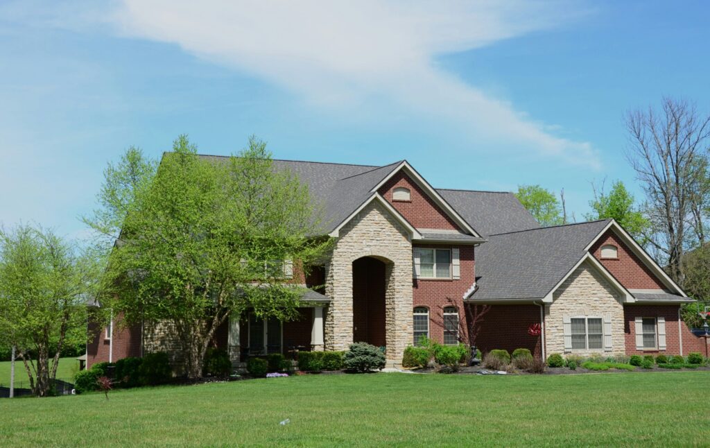 a large brick house with a green lawn in front