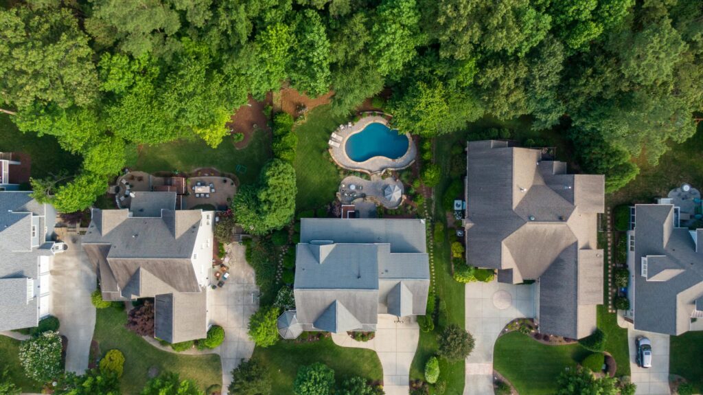 aerial photo of house roofs near green trees